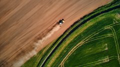 A drone shot of a machine on a dry patch of land